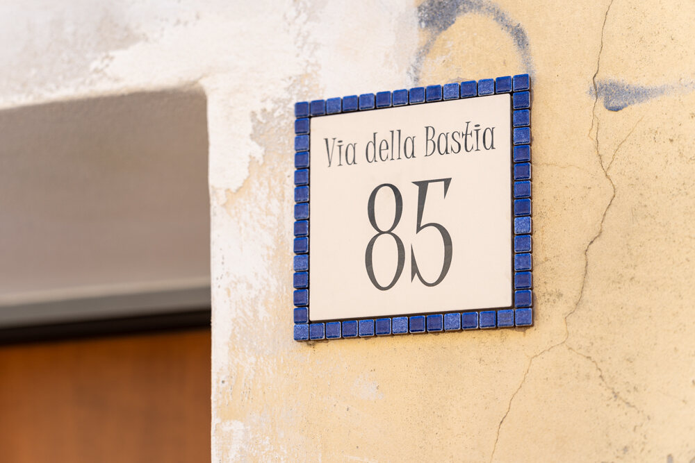 La targa in ceramica all'ingresso dello spazio: Via della Bastia 85